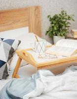 Cup of coffee and book on bed photo