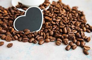granos de café y tarjeta en forma de corazón foto