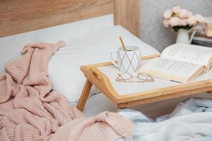 Cup of coffee and book on bed photo