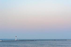 fondo azul marino con faro en el mar, paisaje insular. fondo de mar azul con gaviota, montañas, hermoso cielo y faro. construcción de balizas de navegación en el océano. foto