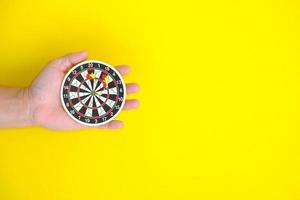 Businessman holding target of business. Dart is an opportunity and Dartboard is the target and goal. So both of that represent a challenge in business marketing as concept photo