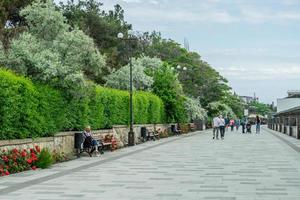 Sudak, Crimea-may 20, 2018 -Beautiful promenade with views of the green fence and vacationing people. photo