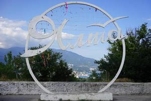 yalta, crimea-23 de junio de 2015-escultura con la inscripción yalta en la vista de la ciudad. foto