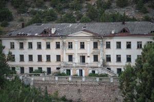 Balaklava, Crimea-June 8, 2016-Destroyed building in Balaklava against the mountains photo