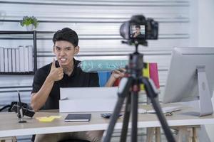 asian man blogger present and review product video broadcast live stream video to a social network. blogging, vlogging, online shopping, and social media concept photo