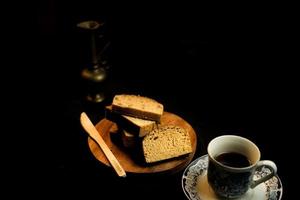 rebanadas de pan en un plato de madera sobre un fondo negro foto