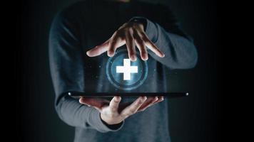 Man holding tablet with the medical cross symbol on the virtual display. life insurance, Medical care, and Healthy business. World Health Day. photo