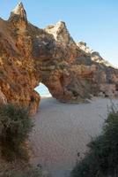 Beautiful natural arch to walk through at a beach in Algarve, Portugal. photo