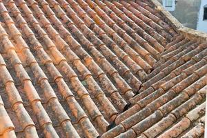 Close up of a rooftop seen from above. Old roof tiles, some of them with moss. Evora, Portugal photo