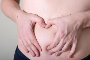 Hand's man touching his fat belly skin. photo