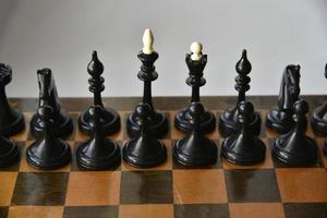 An old chessboard with white and black pieces photo