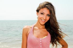 Beautiful woman with long pink dress on a tropical beach photo