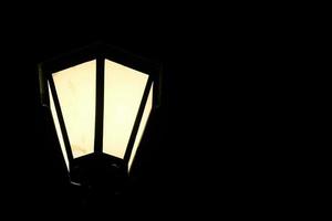 poste de luz de la calle vintage que ilumina la oscuridad al aire libre en el parque de la ciudad, linterna retro brilla en la oscuridad de la noche foto