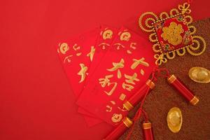 Chinese New Year festival concept. Red envelopes and gold ingots on red background. Chinese character da ji da li meaning great luck great profit and Fu which stands for luck.. photo