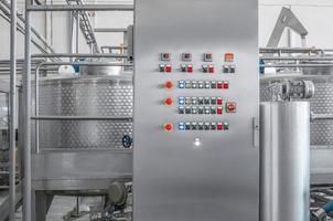 panel de control con botones y un tanque en una fábrica de bebidas, primer plano. tienda de fábrica para la producción de botellas de vidrio y bebidas foto