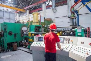 worker behind the dashboard in the workshop for the production of aluminum profiles. aluminum extrusion press photo