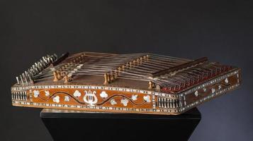 ancient Asian stringed musical instrument on black background with backlight. the similarity of the harp and psaltery photo