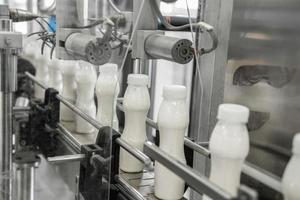 plastic milk bottles on conveyor belt. equipment at the dairy plant photo