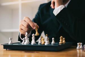 Businessman playing chess game beat opponent with strategy concept. photo