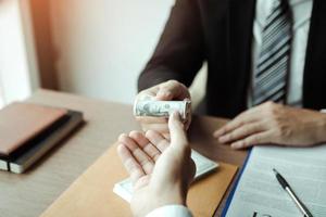 Entrepreneurs are receiving money that is a bribe of their partners with both of whom are corrupt in the company room. photo