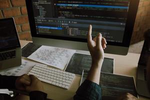 Two software developers are analyzing together about the code written into the program on the computer. photo