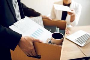 Female manager submits a resignation letter or envelope to the male employee at the office. photo