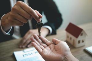 Home agents are handing out keys to home buyers who are signing contracts at the office. photo