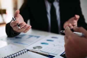 Two business partnership coworkers analysis strategy and gesturing with discussing a financial planning graph and company budget during a budget meeting in office room. photo