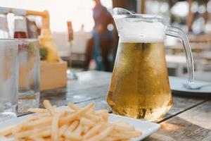 A pitcher of Singha beer with a glass of beer on the table. photo