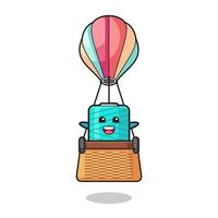 yarn spool mascot riding a hot air balloon vector