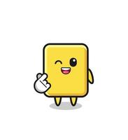 personaje de tarjeta amarilla haciendo corazón de dedo coreano vector