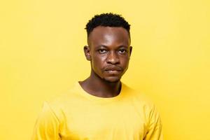 Close up portrait of young African man face on isolated yellow studio background photo