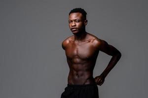 foto de estudio retrato de un joven apuesto hombre africano sin camisa en un fondo gris aislado del estudio