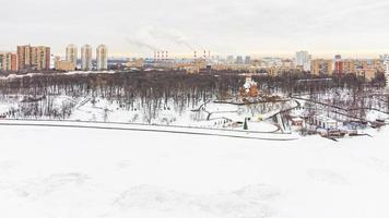 A bird's-eye view of the icy river and the city infrastructure in winter photo