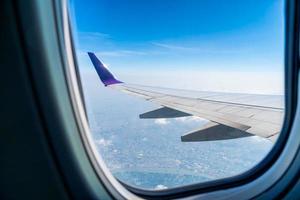 The wings of the plane on the background of blue sky and clouds beautiful. photo