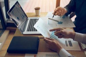 Two business partnership coworkers and gesturing with discussing a financial planning graph and company during a budget meeting in office room. photo