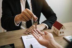 Home agents are handing out keys to home buyers who are signing contracts at the office. photo