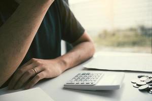 Asian men are stressed about financial problems, with invoices and calculators placed on the table while having stress on problems with home expenses. photo