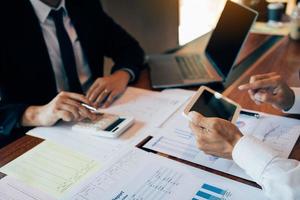 Business partnership coworkers using a tablet to analysis graph company financial budget report and cost work progress and planning for future in office room photo