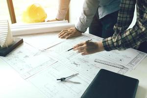 Two engineering man standing examining working on blueprint. photo