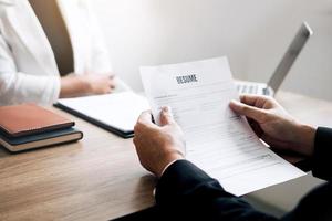 Job applicants are holding a resume document in the job interview room, job interview concept. photo