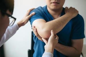 Physical therapists are checking patients elbows at the clinic office room. photo