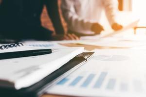 Close up a pen and two business people in a meeting finance and standing at boardroom table having discussion background. photo