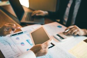 Business partnership coworkers using a tablet to analysis graph company financial budget report and cost work progress and planning for future in office room photo