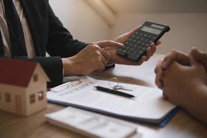 Agents are calculating the loan payment rate or the amount of insurance premiums for customers coming to contact the purchase of a new home at the office. photo