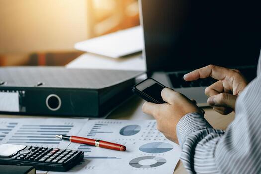 Businessman using smartphone note a summary report and analysis data. photo