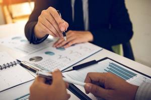 Two business partnership coworkers analysis cost work progress and gesturing with discussing a financial planning graph and company financial during a budget meeting in office room. photo