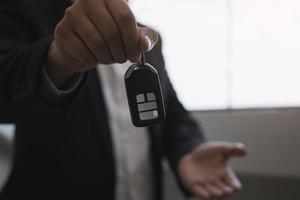 Car sales agent are car keys with the idea of buying a new car. photo