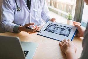 discusiones entre el dentista y el paciente sobre el dolor de los dientes en la clínica. foto