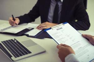 el gerente está escribiendo información personal de los empleados que vienen a solicitar puestos de trabajo en el cuaderno. foto